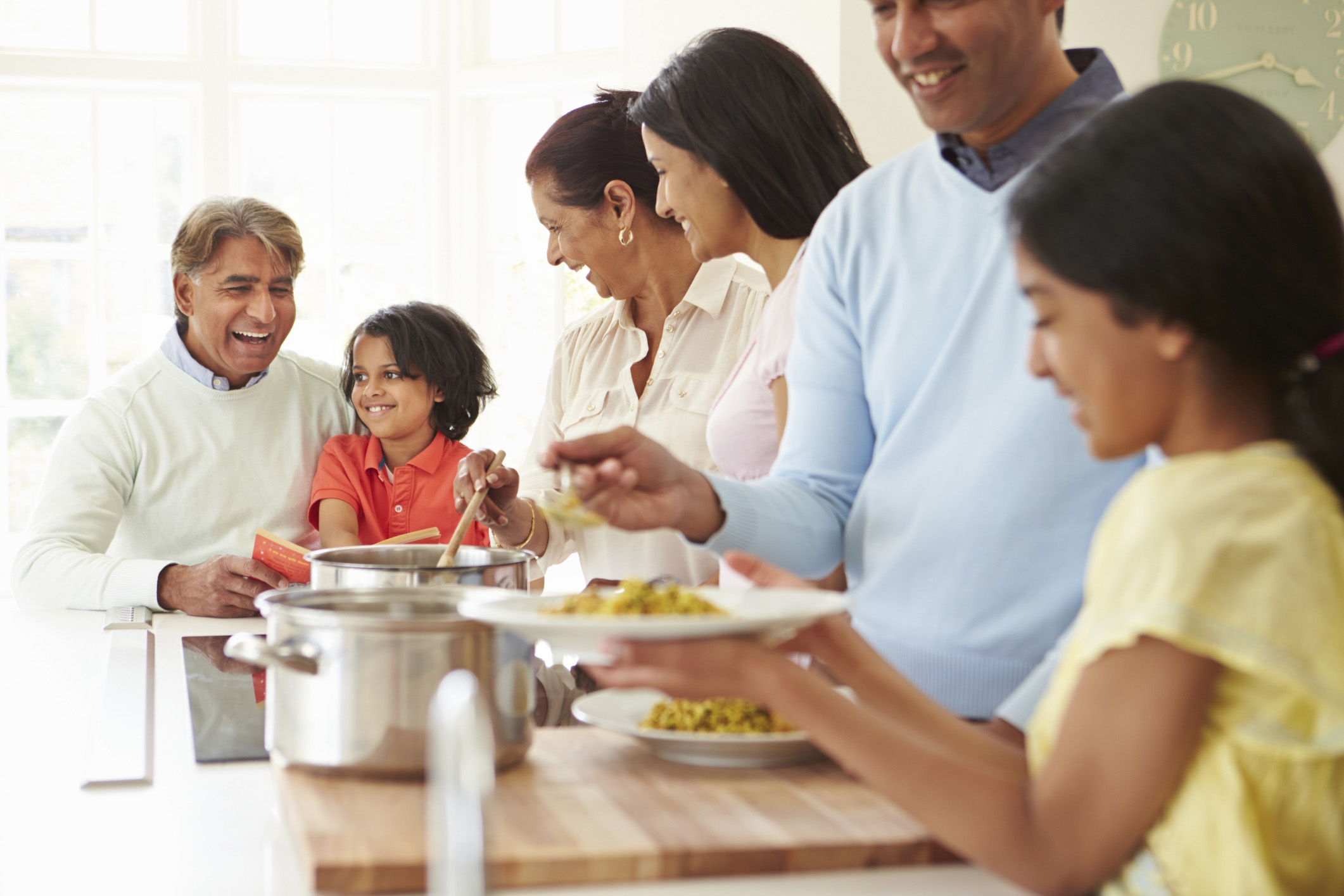 Multi Generation Indian Family Cooking Meal At Home